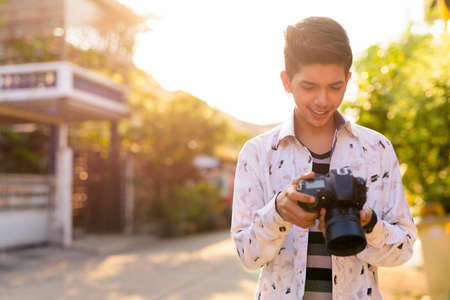 Happy young handsome Indian teenage boy in the streets outdoorsの写真素材