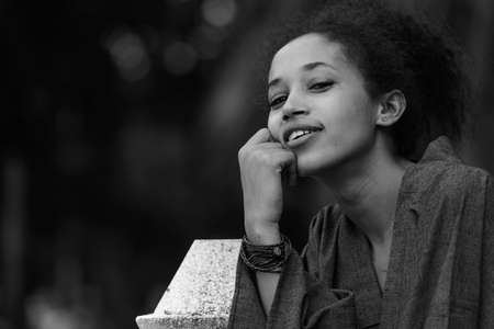 Portrait of happy young beautiful African woman at the park in black and whiteの写真素材