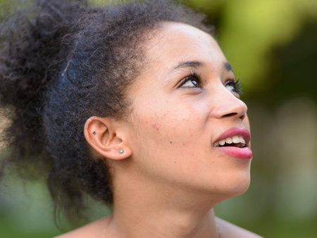 Portrait of happy young beautiful African woman at the park
