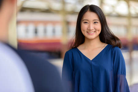 Happy young Asian tourist couple travelling together at the railway stationの写真素材