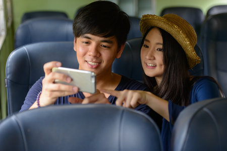 Happy young Asian tourist couple travelling together at the railway station