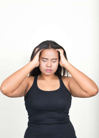 Portrait of young overweight Asian woman against white backgroundの写真素材
