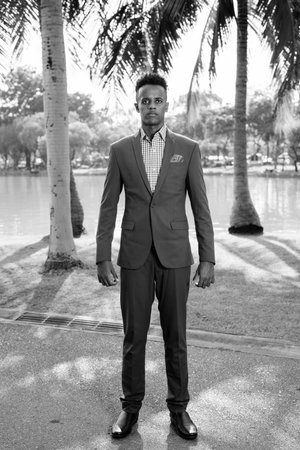 Young handsome African businessman relaxing at the park