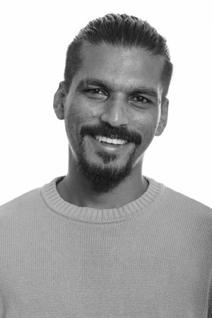 Portrait of happy young handsome bearded Indian man