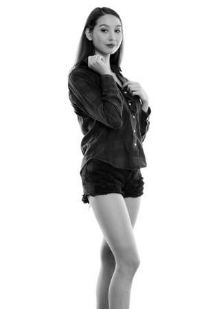 Studio shot of young beautiful Asian woman standing while holding collarの写真素材