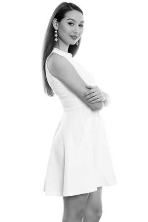 Studio shot of young beautiful Asian woman standing with arms crossedの写真素材