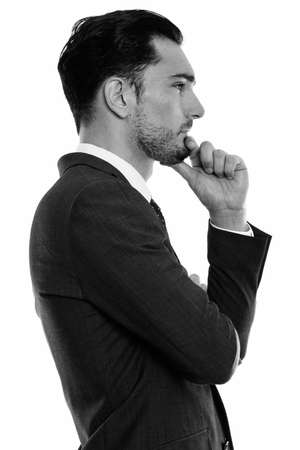 Profile view of young handsome businessman thinkingの写真素材