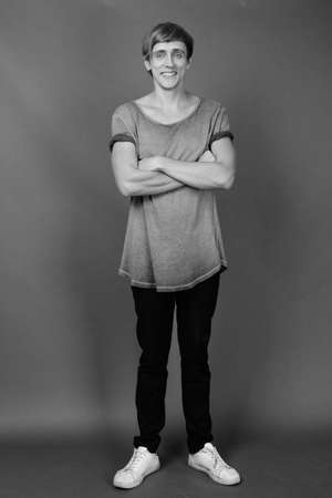 Young handsome man with blond hair against gray backgroundの写真素材