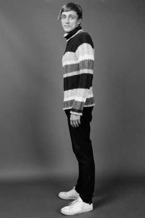 Young handsome man with blond hair against gray backgroundの写真素材