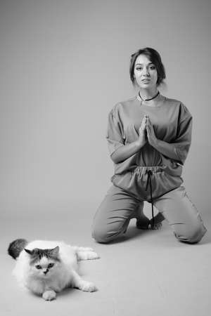 Studio shot of young beautiful woman against gray backgroundの写真素材