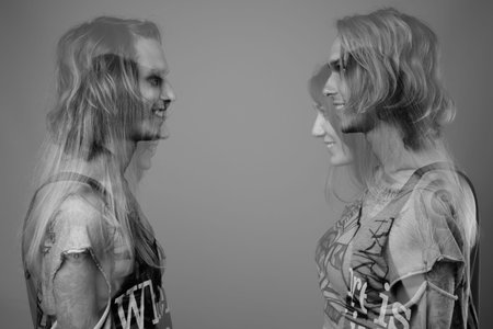Studio shot of young rebellious man and woman together against gray background