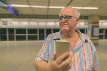 Portrait of overweight senior tourist man exploring around the cityの写真素材