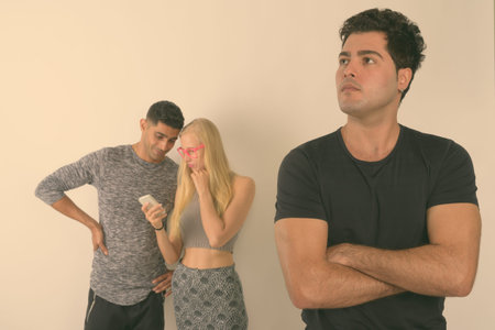 Three multi-ethnic friends together against white background