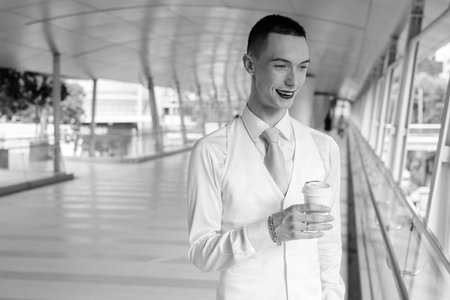 Happy young handsome androgynous businessman exploring around the cityの写真素材