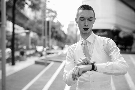 Young handsome androgynous businessman exploring around the city