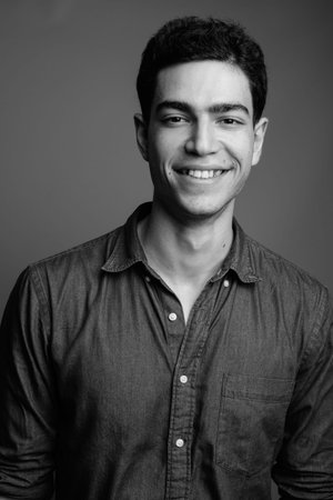 Portrait of happy young handsome Persian businessman smiling