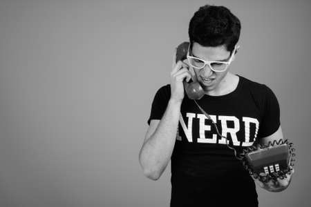 Young handsome nerd man with eyeglasses against gray backgroundの写真素材