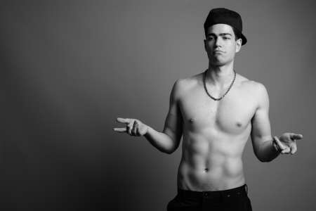 Young handsome man shirtless against gray backgroundの写真素材