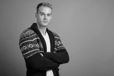 Young handsome man with blond hair against gray backgroundの写真素材