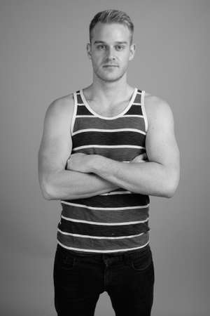 Young handsome man with blond hair against gray backgroundの写真素材