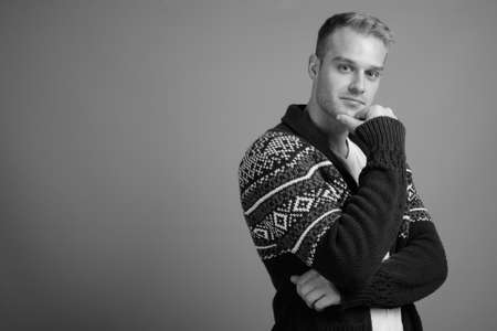 Young handsome man with blond hair against gray backgroundの写真素材