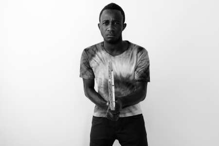 Studio shot of young black African man tennis player against white backgroundの写真素材