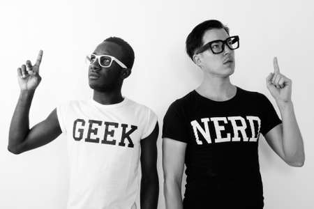 Young African Geek man with European Nerd man thinking and having great idea while pointing finger upの写真素材