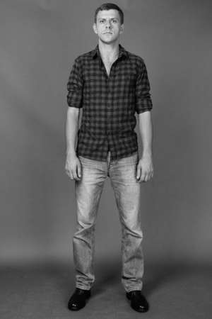 Handsome man with short hair against gray backgroundの写真素材
