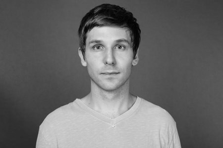 Portrait of young handsome man against gray backgroundの写真素材