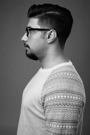 Young bearded Iranian man against gray backgroundの写真素材