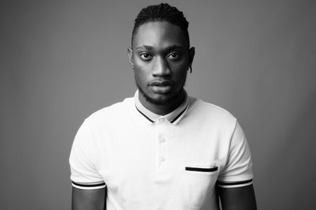 Young handsome African man from Kenya against gray background