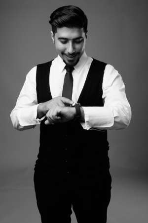 Young bearded Iranian businessman against gray backgroundの写真素材