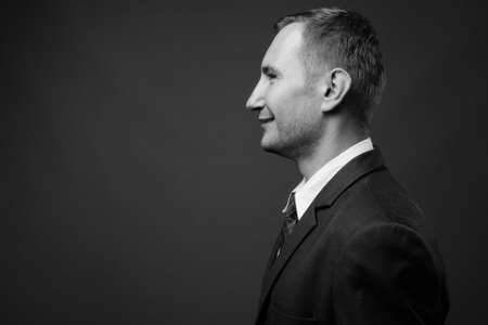 Portrait of businessman in suit against gray backgroundの写真素材