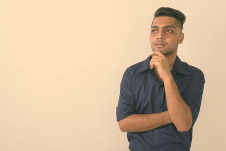 Portrait of young Indian businessman against white backgroundの写真素材