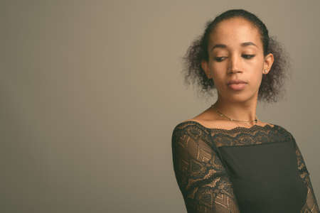 Young beautiful African woman against gray backgroundの写真素材