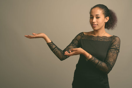 Young beautiful African woman against gray backgroundの写真素材