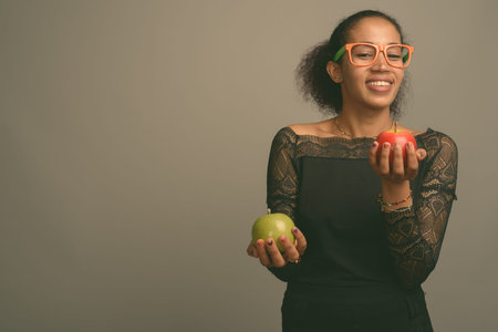 Young beautiful African woman against gray backgroundの写真素材