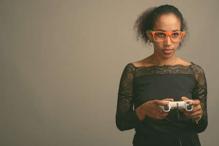 Young beautiful African woman against gray backgroundの写真素材