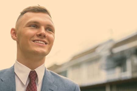 Portrait of happy young businessman in the streets outdoorsの写真素材