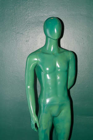 Green naked man mannequin inside green artistic studio roomの写真素材