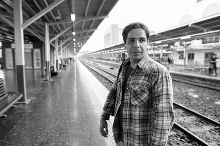 Portrait of handsome Persian tourist man at the railway station
