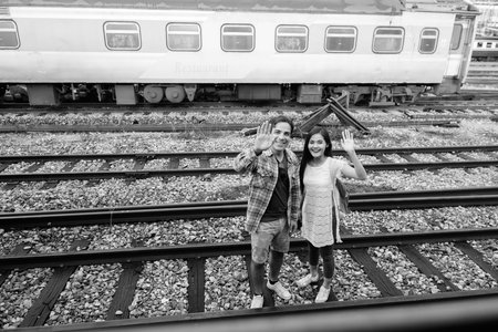 Persian tourist man and young Asian tourist woman together at the railway station