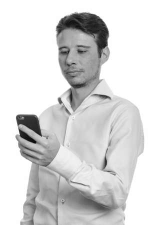 Portrait of handsome businessman with beard stubble using phoneの写真素材