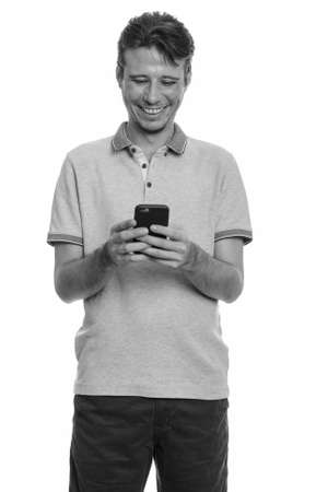 Portrait of happy handsome man using phoneの写真素材