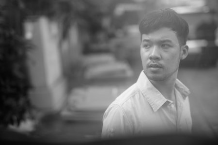 Young Asian businessman thinking in the streets outdoors