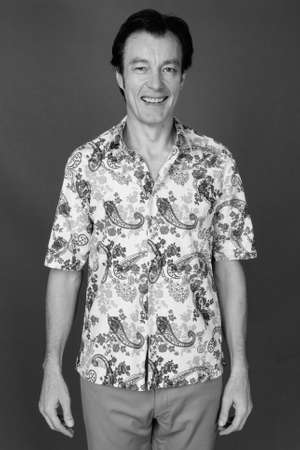 Mature handsome tourist man against gray backgroundの写真素材