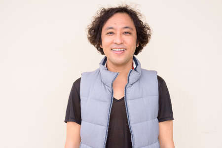 Portrait of happy Japanese man with curly hair smilingの写真素材