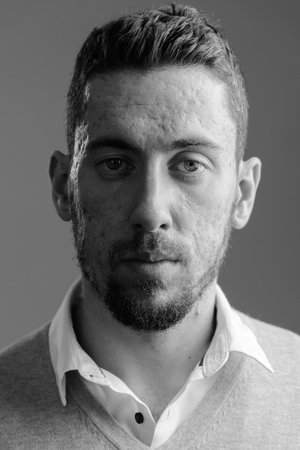 Face of young handsome bearded man looking at camera