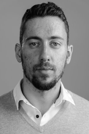 Face of young handsome bearded man looking at camera