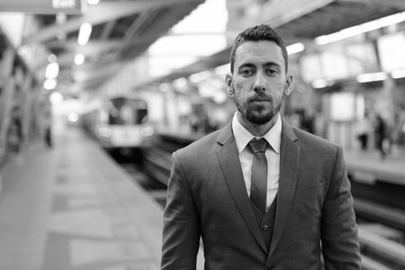 Young handsome Caucasian businessman at train station in Bangkok Thailand
